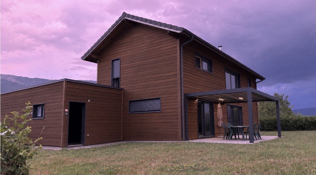 Maison à ossature bois, vue extérieure au crépuscule